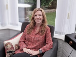 Image of Joanne Brown from Evolve Counselling smiling and sitting in chair.