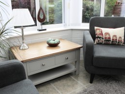 Second image of session room at Evolve Counselling showing chair, table, sofa, lamp and cushions.